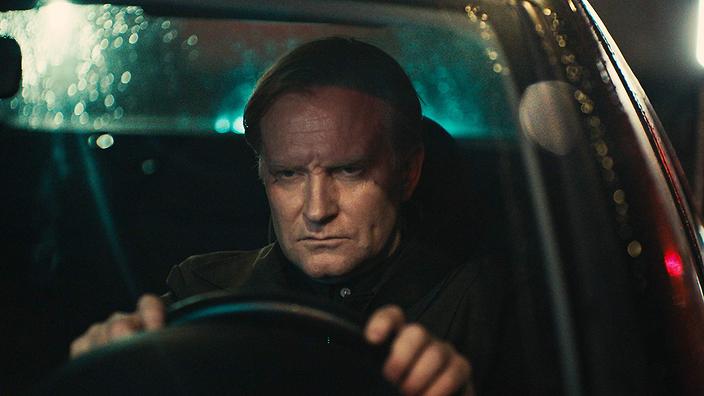 Face to Face Image with Ulrich Thomsen as Bjørn Rasmussen driving intently